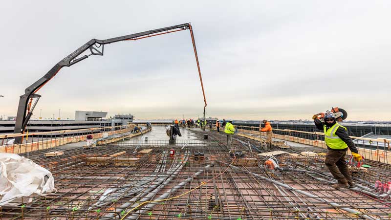 Less Than a Year After Groundbreaking, MCR & Morse Development Top Out the TWA Hotel New York Airport 10 TWA Topping Out Workers pour concrete on top floor of north hotel structure Max Touhey Metropolitan Airport News