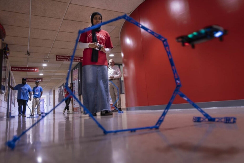 Student Afsa Fatima operating a drone through an obstacle course.