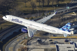 February 2023 Publisher’s Message An air-to-air shot taken from a helicopter of a jetBlue A321neo banking out of JFK Airport.